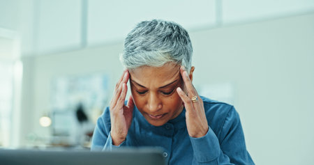 Mature, frustrated woman or stress with headache for pressure, deadline or overworked at office....