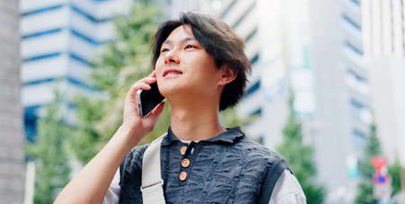 Japanese man, happy and phone call in city for conversation, discussion and booking with travel. Asian person, talking and mobile outdoor for listening, communication and morning commute with chatの写真素材