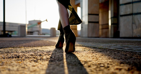 Business, walking and feet of woman in city with sunrise, travel and metro station for transport. Urban, sidewalk and shoes of professional businesswoman on morning commute with high heels on groundの写真素材