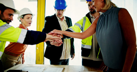 Architecture, teamwork and hands together with people on construction site for building, real estate and support. Engineer, collaboration and property developer with employee for renovation meetingの写真素材