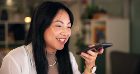 Asian businesswoman, speaker and phone call in home for remote work with sales, creative agency or ideas. Night, consulting or voice recording of brand consultant speaking of planning startup projectの写真素材