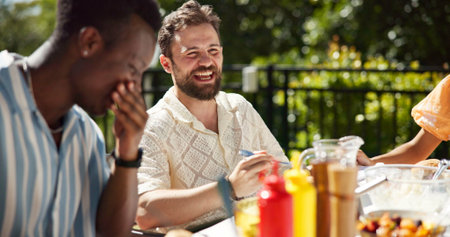 Party, food and friends laughing outdoor for new year celebration, funny joke or bonding together. Terrace, people or happy with lunch at social event for festive reunion, holiday or fun conversationの写真素材