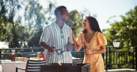 Bbq, drinks and couple of friends outdoor for social gathering, laughing and funny joke at reunion party. New years celebration, woman and man cooking lunch on terrace with bonding or festive holidayの写真素材