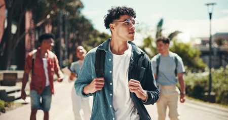 Education, man and walking with student friends outdoor together for learning or study at university campus. College, future and thinking with learner group at school for knowledge or scholarshipの写真素材