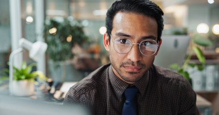 Portrait, research and man in office with glasses for novel, creative agency or self publishing. Online, entrepreneur and person with vision, computer and editing of ebook for release or writerの写真素材