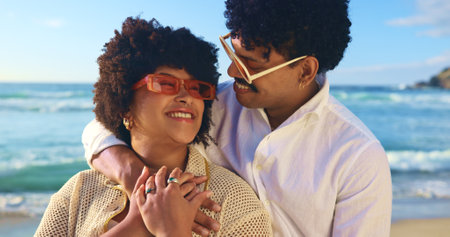 Hug, beach and couple with love, travel and summer holiday with weekend break, smile and romance. People, seaside and man with woman, sunglasses and embrace with honeymoon, adventure and relationshipの写真素材