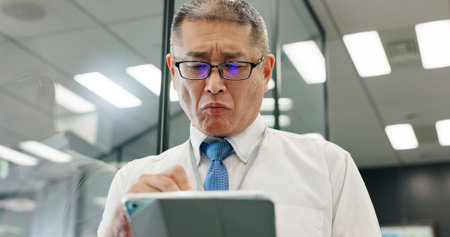 Tablet, mature and business man research online, reading email or check insurance policy on app. Japanese person, digital technology or manager planning project, risk management or feedback in officeの写真素材