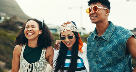 People, laugh and walking on beach outdoor for travel reunion, summer vacation and embrace of funny joke. Smile, friends and sunglasses for holiday journey, social gathering and weekend trip at oceanの写真素材
