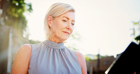 Tablet, outdoor and mature business woman check email, schedule or environmental urbanist reading information. Digital technology, manager and professional in city for sustainable development projectの写真素材