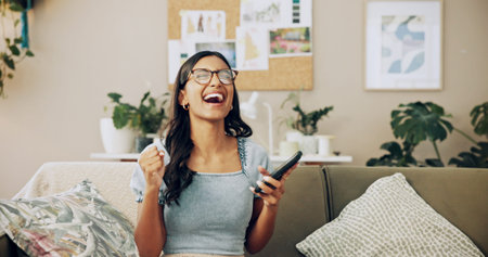 Winner, phone and success with woman on sofa for bonus, online shopping deal and achievement. Good...