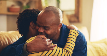 Bonding, hug or love with dad and son on sofa in living room of home together for development. Black family, happy or support with boy child and single parent man embracing in apartment for caringの写真素材