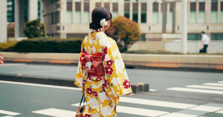 City, walking and woman on crosswalk with kimono, morning commute and sightseeing in traditional clothes. Explore, discover and girl with Japanese fashion, culture or urban street on travel from backの写真素材