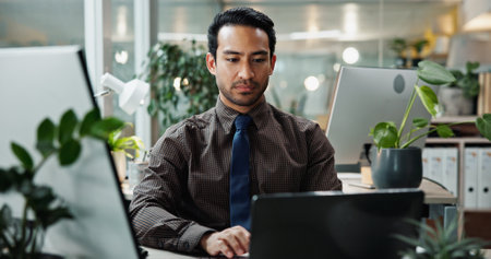 Asian, research and businessman in office with laptop for typing, creative agency or self publishing. Online, writer or worker with internet, computer or pc for editing of ebook novel with technologyの写真素材