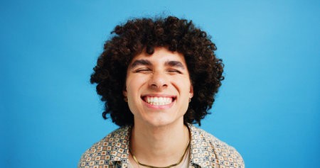 Studio, man and wellness with smile for dental, teeth whitening and confidence after cleaning treatment. Mockup space, male person and happy with results for oral hygiene, veneers and blue backgroundの写真素材