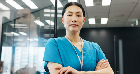 Portrait, woman and nurse with confidence in hospital for healthcare services, about us and medical advice. Female surgeon, arms crossed and career ambition, diagnosis and treatment trust in Japanの写真素材