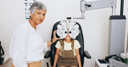 Machine, doctor or kid in eye test at optometry clinic for eyewear, retina health or sight wellness. Optical phoropter, mature or child in assessment for visual help, vision exam or spectacles framesの写真素材