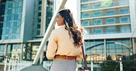 Outdoor, business and woman with thinking or commuting to workplace with ideas and vision in city. Back view, female person and employee with thoughts for new job work in morning with mindsetの写真素材