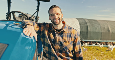 Man, farmer and smile in portrait by tractor, outdoor and free range chicken on field in summer. Person, happy and vehicle for agriculture at sustainable poultry farm with sunshine in Costa Ricaの写真素材