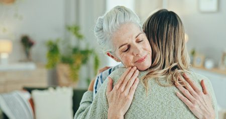 Pensioner woman, caregiver and hug with empathy for healthcare, comfort and treatment in senior care at home. People, therapist and embrace for elderly patient, trust or support checkup in retirementの写真素材