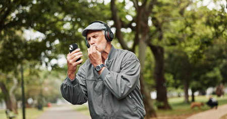 Headphones, senior man and phone for winning in park with good news, online giveaway and gambling...