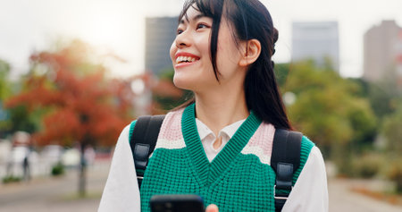 Phone, travel and Japanese woman in city with navigation for university with mobile app. Happy, cellphone and female student with directions for college campus with international exchange program.の写真素材