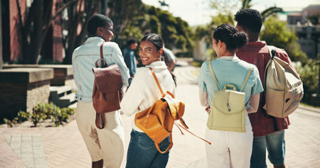 Development, education and walking with student friends outdoor together for learning or study at university. Back, college and portrait with learner group on campus for knowledge or scholarshipの写真素材
