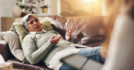 Relax, therapist and patient in office for mental health, stress or anxiety at appointment. Conversation, medical and mature woman talking to psychologist for advice in consultation at clinic.の写真素材