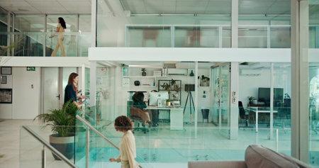 Modern building, walking and business people in office for coworking, productivity and synergy. Professional, corporate and workers in glass workplace for meeting, working and busy for career or jobの写真素材