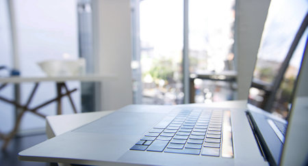 Laptop, keyboard and online in workspace closeup, interior and equipment for networking career. Buttons, wireless technology and internet connection for website, communication and desk at workplaceの写真素材