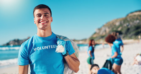 Volunteer, bag and portrait of man on beach for cleaning dirt, plastic and litter for ocean pollution. Community service, charity and person for environmental care, recycling and climate changeの写真素材