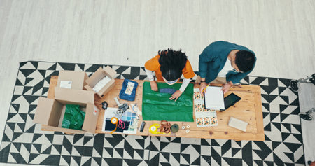 Small business, people and packaging clothes for shipping with online order, product distribution or teamwork. Fashion store, top view or employee wrap parcel for courier delivery or export inventoryの写真素材