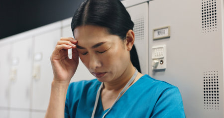 Japanese, woman and surgeon with headache in hospital of healthcare stress, medical mistake and burnout risk. Nurse, depression and anxiety of surgery crisis, bad news and treatment disaster in Japanの写真素材