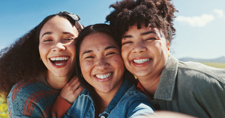 Women, friends and selfie with outdoor field for summer adventure, portrait and nature in countryside. Girl group, park and photography for online, social media and blue sky for sunshine or springの写真素材