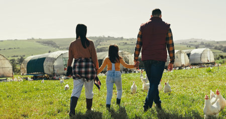 Back, holding hands and family with agriculture, farm and bonding together with sustainability. Parents, outdoor and mother with father, girl and child with nature, environment and countrysideの写真素材