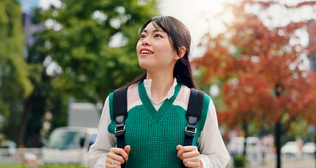 Japanese, woman and thinking for smile outdoor with sightseeing view, morning commute and vacation journey. Person, travel and backpack for holiday adventure, nature scenery and tourism trip in Japanの写真素材