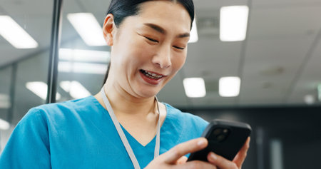 Happy woman, nurse or phone in hospital for news, schedule update or connectivity. Japanese surgeon, smile or mobile in clinic for positive feedback, patient recovery or healthcare email with resultsの写真素材