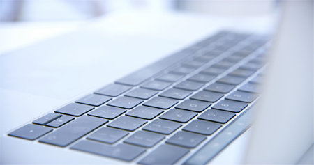 Laptop, keyboard and empty office for modern tech, interior and equipment for networking career. Buttons, wireless device and internet connection for website, communication and desk at workplaceの写真素材