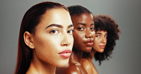Women, inclusion and confident for skincare in studio background for diverse beauty. Natural, people and serious or proud with glow on portrait in row for empowerment, body care and skin treatmentの写真素材