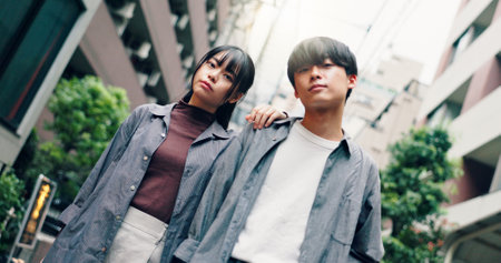 Japanese couple, portrait and fashion in street with confidence on travel, attitude or clothes in city. Man, woman and together with partner, love or trendy with streetwear in low angle on urban roadの写真素材