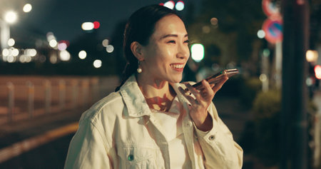 Phone call, record and Japanese woman in city for ai virtual assistant, speaker and voice memo. Reminder, communication and audio with asian person at night for networking, contact and soundの写真素材