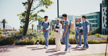 Medical student, university and professor with people in outdoor for college, healthcare and teacher. Scholarship, internship and doctors with students on hospital campus for assignment and educationの写真素材