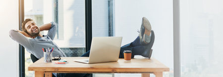 Happy man, relax or banner with laptop for productivity, done or completion at office desk. Male person, creative or designer with smile or computer for break, rest or finished with task at workplaceの写真素材