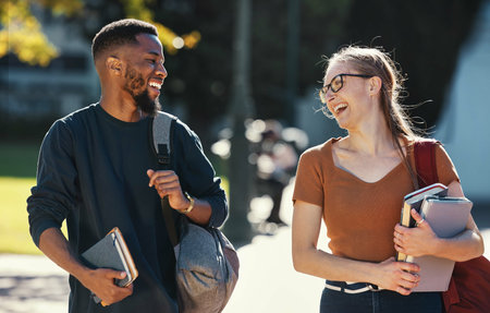 Education, diversity friends and students walking to college lecture class, school campus and talking on fun journey. University study, communication and learning black man and woman happy on travelの写真素材
