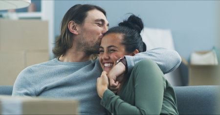 Happy couple, hug and boxes in new home with kiss, support and pride for investment opportunity....