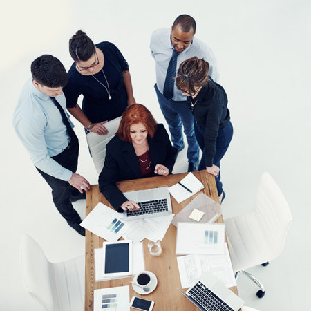 Woman, group and business people by laptop, collaboration and above for documents, feedback or charts. Person, team and planning with diversity, graphs or review stats for economy at financial agencyの写真素材