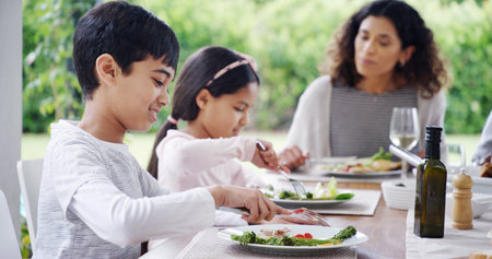 Family, dinner or children with food outdoor for eating, festive celebration and social gathering. Thanksgiving, people and healthy meal together on patio with love, holiday lunch and bonding by homeの写真素材
