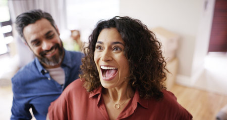 Happy couple, shock and new home with surprise for relocation, gift or moving in together. Excited man, woman or lovers with present, house or apartment for anniversary, celebration or renovationの写真素材