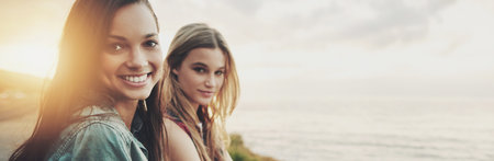Travel, smile and view with friends in beach for explore, bonding and summer vacation. Sunset, mockup space and portrait with women and ocean for holiday, adventure and seaside banner with lens flareの写真素材