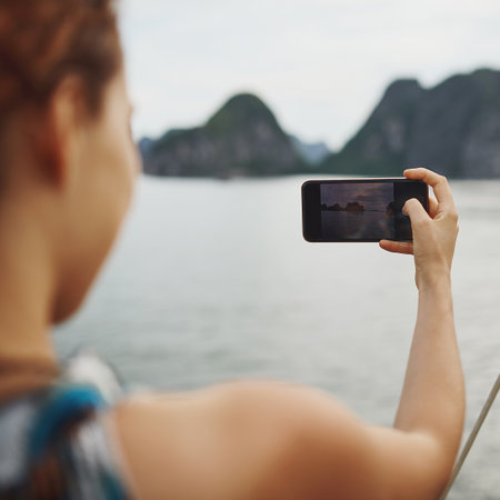 Cellphone screen, photography and woman by ocean for travel, vacation or weekend trip for blog online. Adventure, phone and female person with picture by sea on boat on holiday for memory or explore.の写真素材