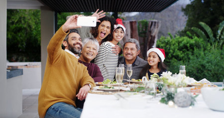 Christmas, happy or family with selfie at dinner by home for holiday memory, profile picture update or bonding. People, parents or grandparents with kids on patio for celebration, care or photographyの写真素材